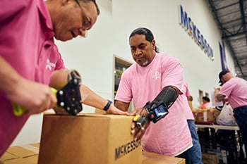 Workers in a warehouse sealing a box