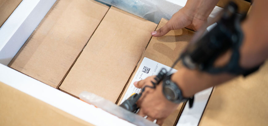 Close up of hands opening a cardboard box.