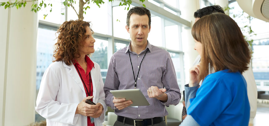 <i><span>Medical professionals having discussion in hospital lobby</span></i>