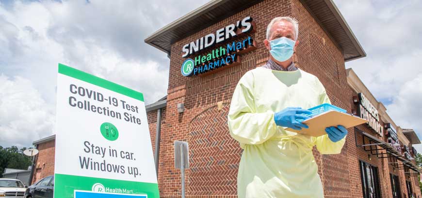 A healthcare worker standing in front of a Snider's Health Mart pharmacy building