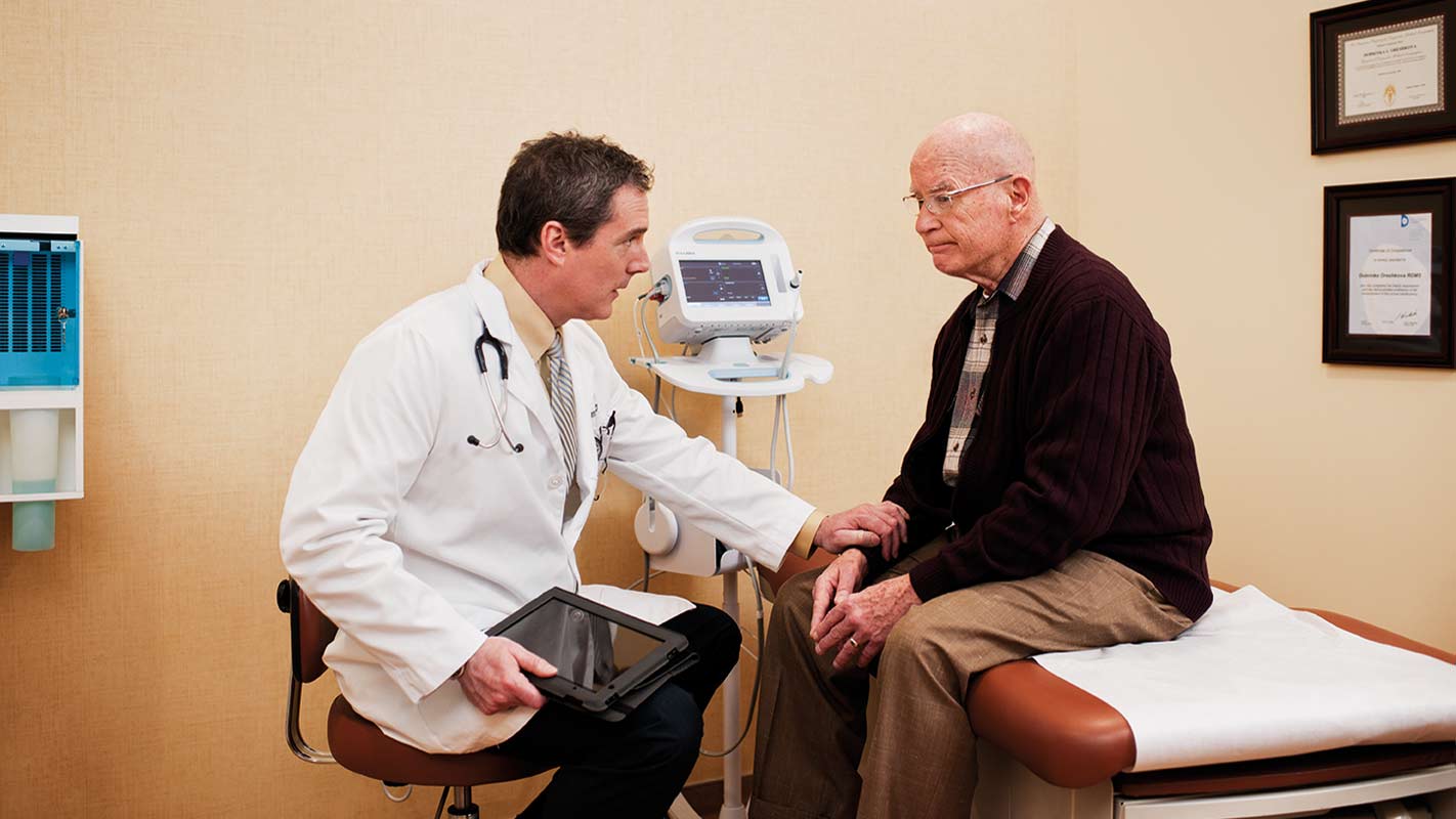 A doctor speaking with a patient in an exam room