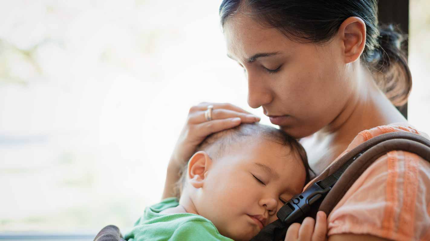 A mother holding her sleeping child