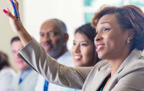 A woman raises her hand in a meeting