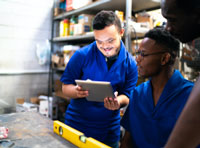 Two warehouse workers looking at a tablet