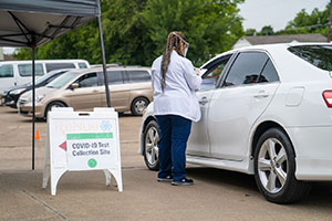 A Health Mart pharmacist administers a COVID-19 test to a patient.