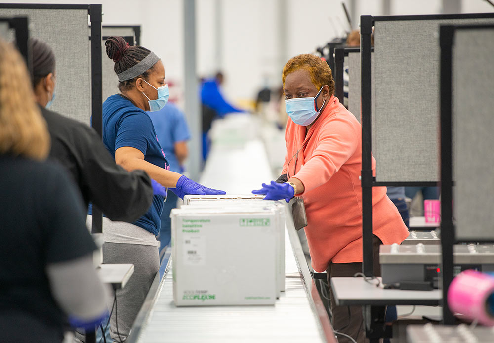 Distribution center employees inspect packages ready for shipping