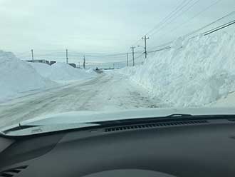 View from truck windshield while driving through a blizzard