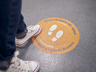 Person standing on a designated 6 feet apart floor marker