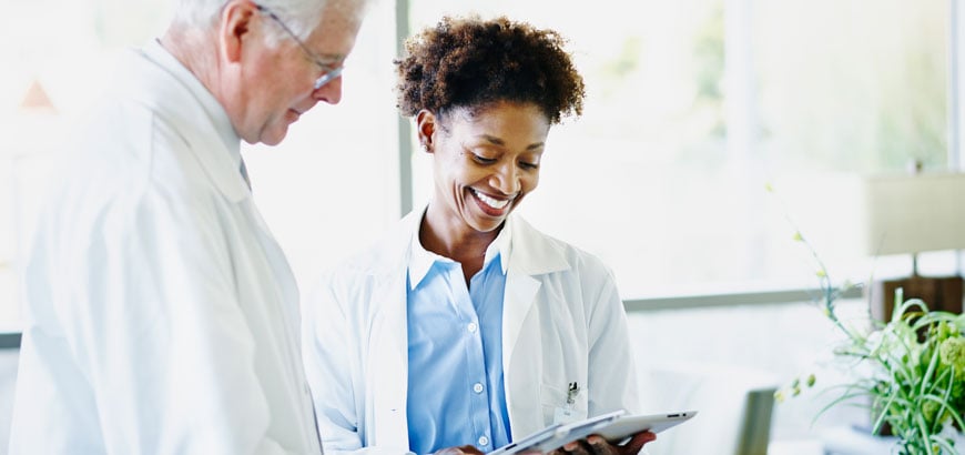 <span>Doctor and pharmacist reading a tablet</span>