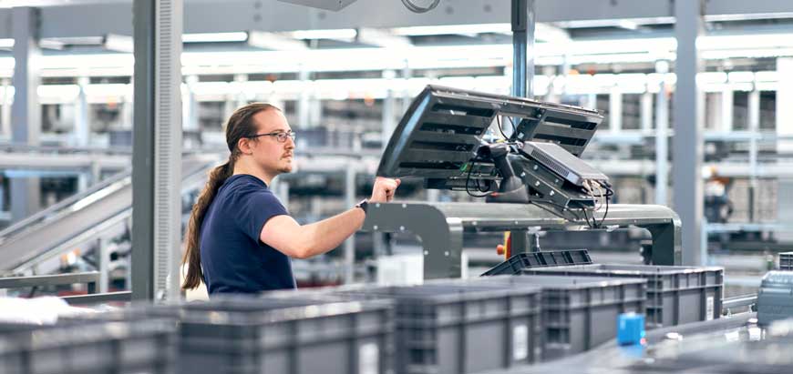 A worker stands at the assembly line