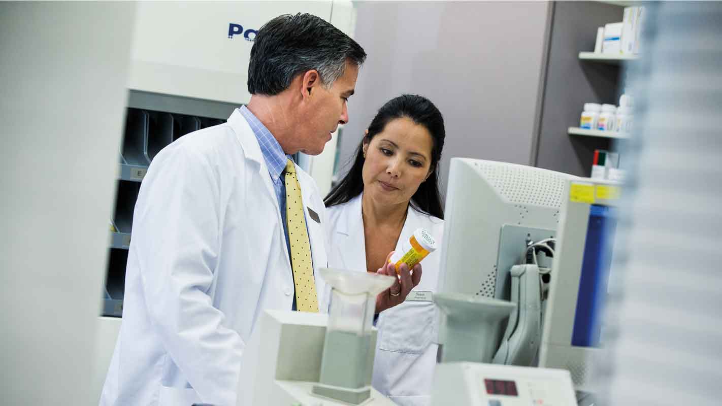 Two pharmacists discussing a prescription drug in a pharmacy