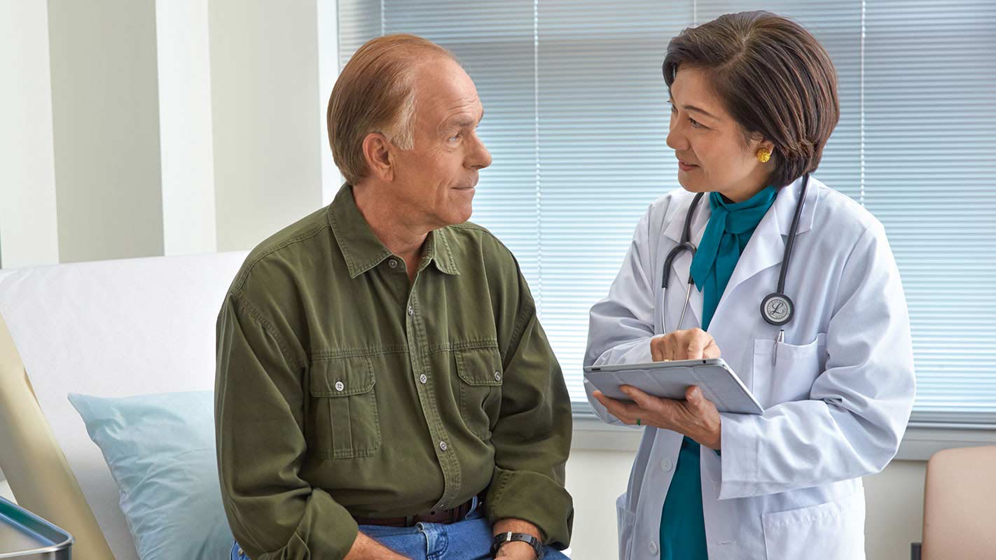 A doctor speaking to a patient in an exam room