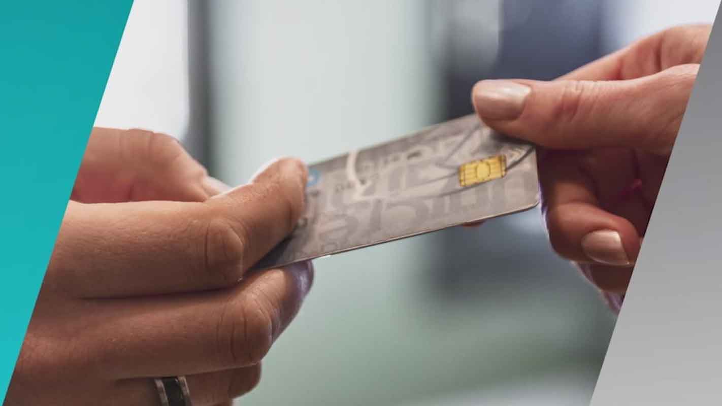 Closeup of a person handing another person a credit card