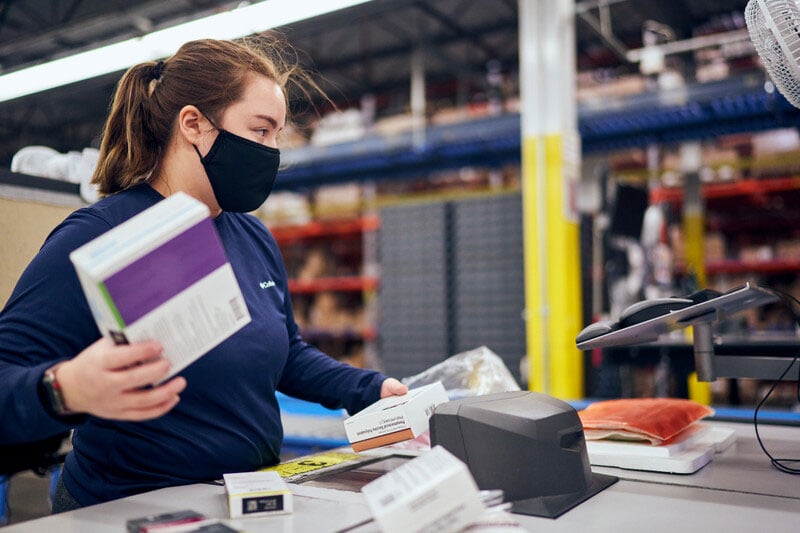 A woman working on an assembly line in a distribution facility