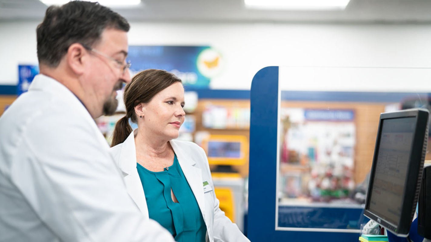 Two pharmacists looking at a computer monitor