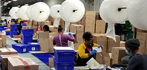 Workers in a distribution center working at an assembly line