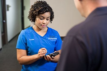 A nurse working on a handheld tablet