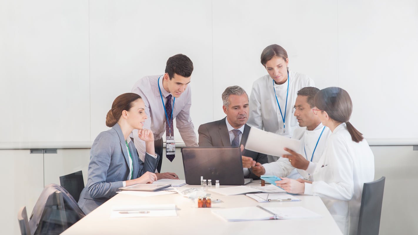 People sitting at a conference table reviewing a document